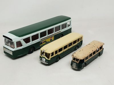 trois bus miniatures posés les uns à côté des autres sur une surface blanche