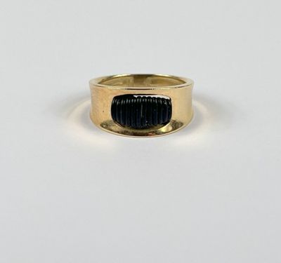 gros plan d'une bague en or contenant une pierre noire