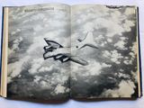 an open book with a picture of a plane flying in the sky