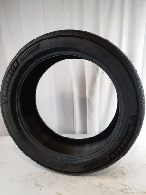 a close up of a tire on a white surface with a curtain in the background