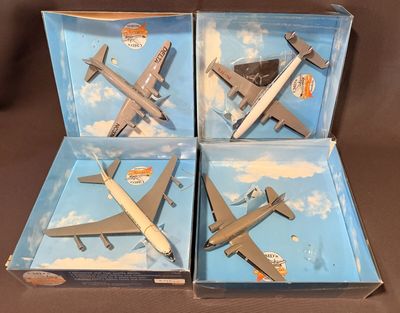 quatre avions miniatures se trouvent dans une boîte posée sur une surface marron