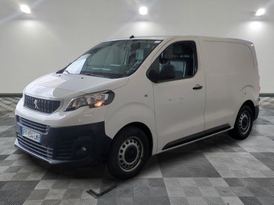 la camionnette blanche est garée sur un sol en damier dans le garage