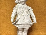une photo représentant la statue d'une petite fille debout sur une table