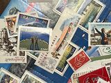 une pile de timbres posée sur une table, à côté d'une paire de ciseaux