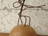 a metal sculpture of a man on a rock on a table