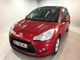 La voiture rouge est garée dans le garage de l'immeuble.