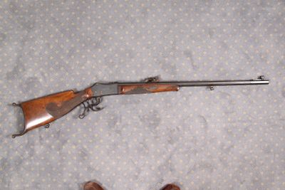 un pistolet et un fusil posés sur un lit