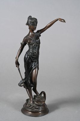 une statue antique en bronze représentant une femme tenant un chien