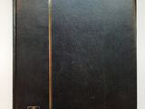 un vieux livre à la couverture noire posé sur une table