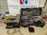 une valise remplie d'outils posée sur une table, avec une pancarte en arrière-plan
