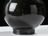 a black vase sitting on top of a white table