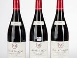 trois bouteilles de vin rouge posées sur une table blanche