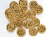 some gold coins on a white surface with a white background