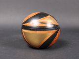 an orange and black striped wooden box sitting on top of a table