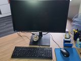 a computer desk with a monitor, keyboard, mouse and mouse pad