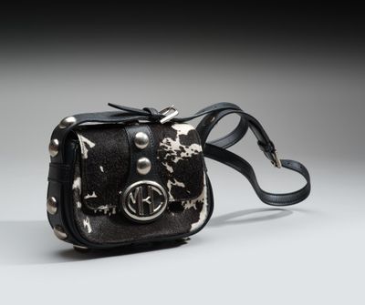 sac à bandoulière noir et argent parsemé d'étoiles sur fond gris