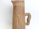 a brown pitcher that is sitting on a white surface