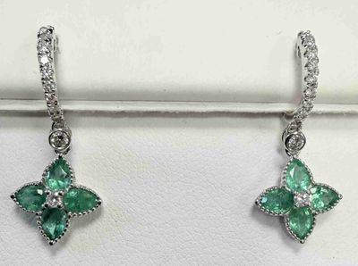 une paire de boucles d'oreilles en émeraude et diamant exposée dans une bijouterie