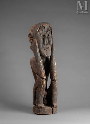 une statue en bois représentant un homme tenant sa tête entre ses mains