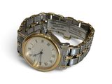 a silver and gold wrist watch with roman numerals on it