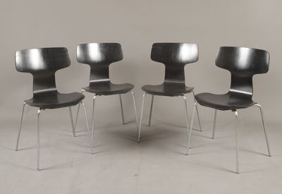 trois chaises noires placées les unes à côté des autres sur un sol blanc