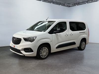La camionnette blanche est garée dans une grande pièce aux murs blancs.