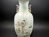 un vase blanc avec un tableau posé sur une table