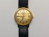 une image représentant une montre en or avec un bracelet noir