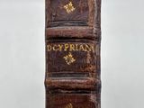 an old book sitting on top of a wooden table next to a white wall