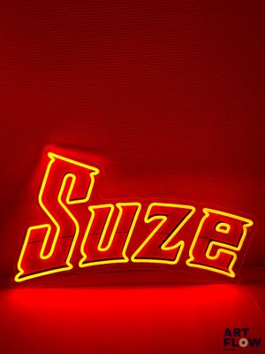 une enseigne au néon rouge sur laquelle est inscrit le mot « suze »