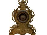 a gold clock that is sitting on a stand