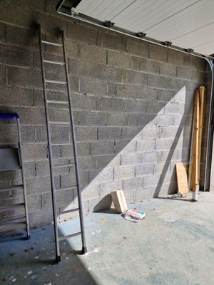 une échelle appuyée contre un mur à côté d'un immeuble