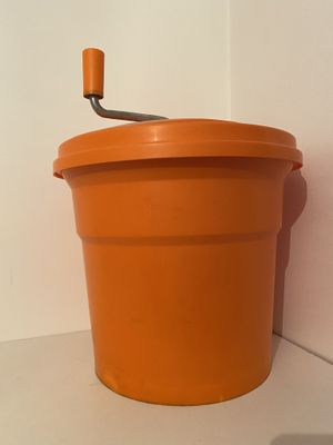 an orange bucket with a handle sitting on a shelf