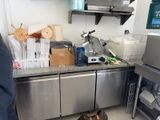 un homme debout dans une cuisine, près d'un plan de travail
