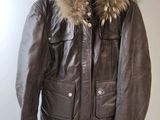 brown leather jacket with fur collar and cuffs hanging on a hanger