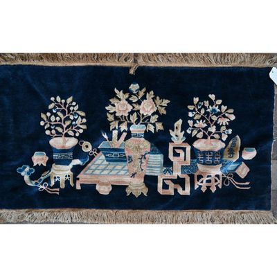 une image représentant un tapis bleu orné d'un motif représentant un train et des fleurs