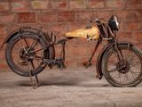 a old motorcycle that is sitting in front of a brick wall