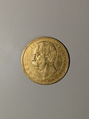 gros plan d'une pièce d'or sur une surface blanche