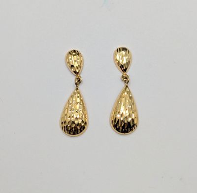 une paire de boucles d'oreilles dorées ornées d'un pendentif en forme de larme