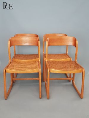 deux chaises en bois avec des assises tressées, adossées à un mur gris