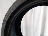 a close up of a tire on a white surface with a white curtain in the background