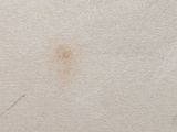 a brown stain on the wall next to a white wall