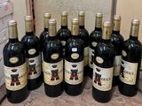 several bottles of red wine are lined up on a counter
