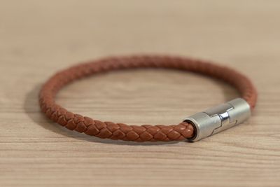 leather bracelet with a silver clasp on a wooden surface