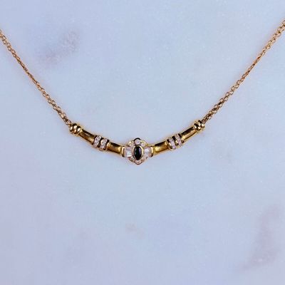 un gros plan d'un collier en or orné d'une pierre noire