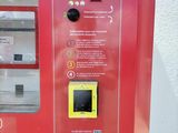 a red vending machine with buttons on it