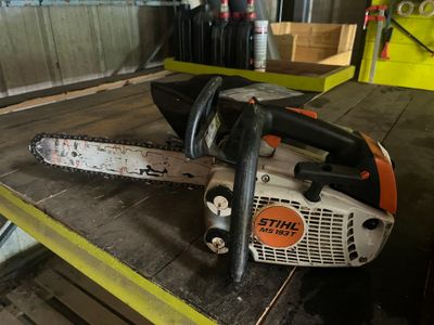 une tronçonneuse posée sur une table dans un garage