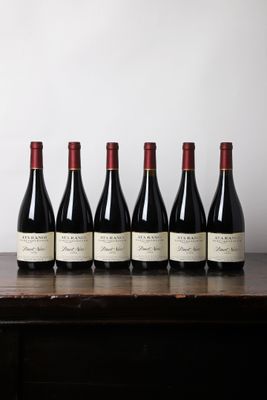 six bouteilles de vin alignées sur une table en bois