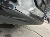 a close up of a car ' s front bumper with a denting on it