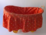 a red basket with yellow wheels on a white background